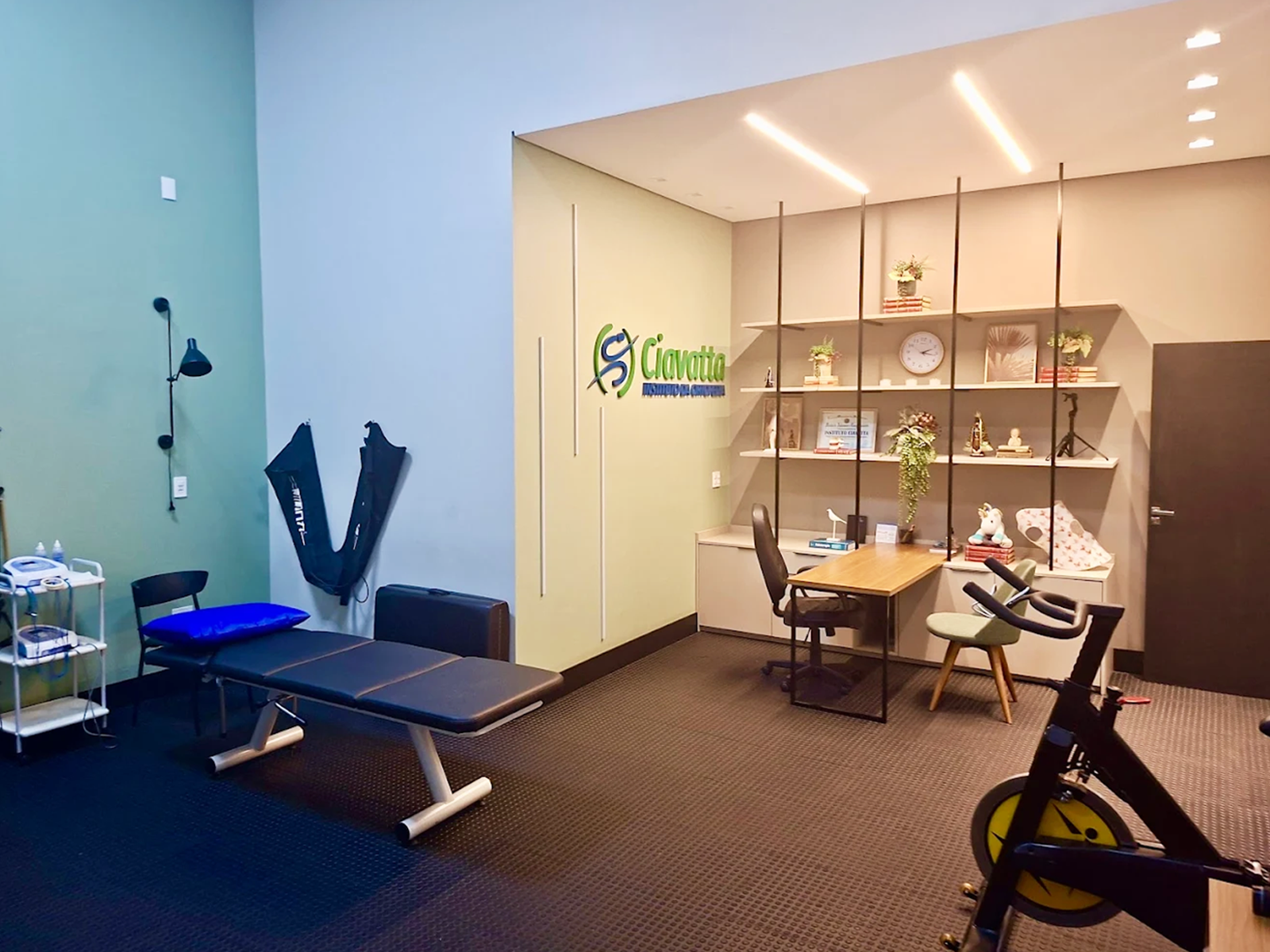 Sala de atendimento com maca e equipamentos de fisioterapia